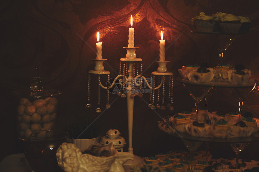 在家里黑暗背景下烧蜡烛古老的风格平静浪漫气氛室内的蜡烛青铜台和深暗背景下烧蜡烛设计水平图像图片