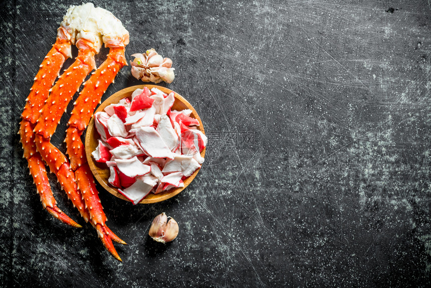 螃蟹肉在盘子上大蒜花朵上蟹肉在盘子里大蒜花圈上图片