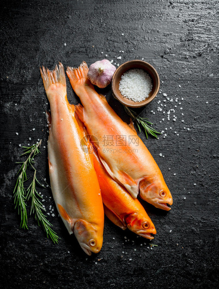 含迷迭香大蒜和盐的生鱼鳟黑本底含迷迭香大蒜和盐的生鱼鳟图片