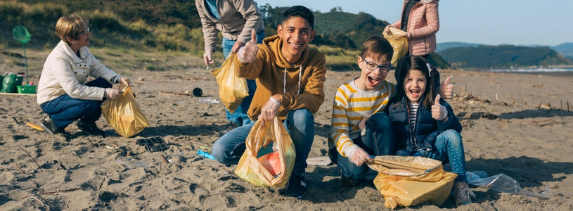 青年男子和儿童在海滩上打扫图片
