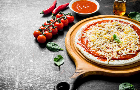 准备披萨面团加番茄糊奶酪和樱桃番茄黑生化背景图片