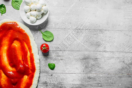 生披萨面粉番茄糊和菠菜白木本底图片