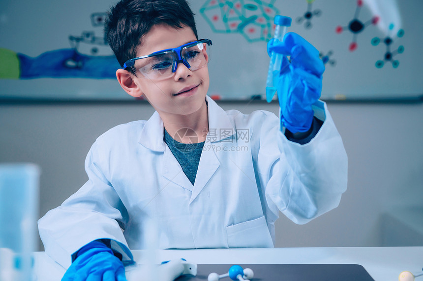 男孩在实验室大衣持有测试管实验在学校图片
