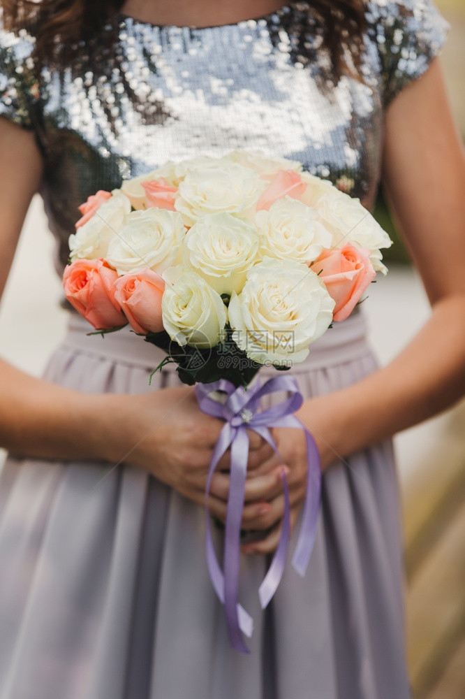 新娘穿着优雅的婚纱盛着一束美丽的花朵和绿色叶子婚礼主题穿着优雅的婚纱新娘拿着一束美丽的花朵和绿色叶子图片
