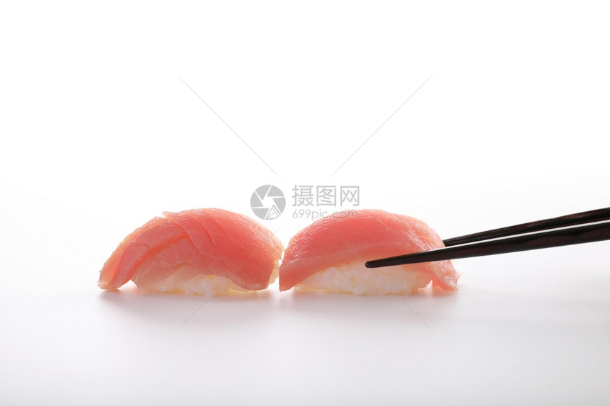 金鱼寿司用白种的筷子隔绝在白种背景中图片