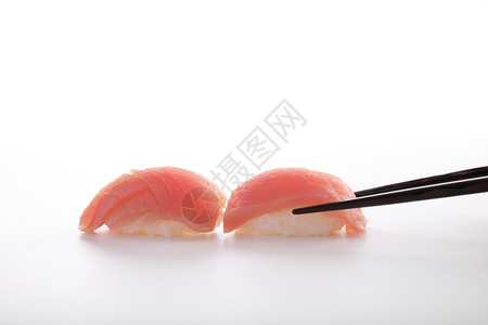 金鱼寿司用白种的筷子隔绝在白种背景中图片