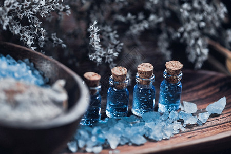 关闭用于芳香疗法的木制和蓝色温泉场所的照片基本油海盐木碗白花背景图片