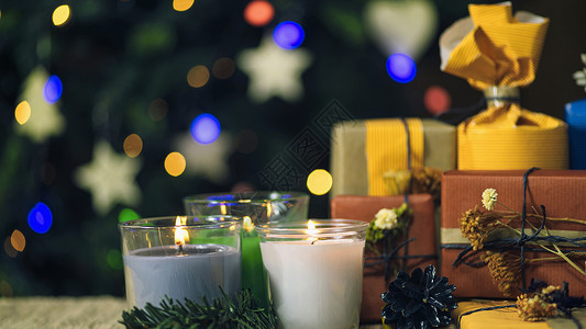 圣诞礼物装在手工制作的盒子和装饰圣诞树上背景有彩色的灯光没有焦点背景图片
