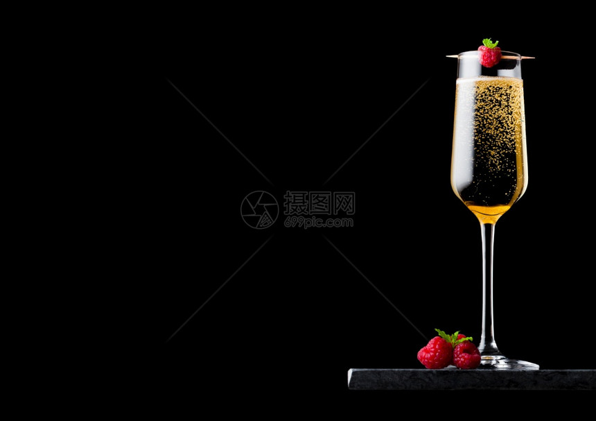 优雅的黄色香槟杯子上面有香草和鲜莓还有薄荷叶在黑大理石板上粘黑大理石板图片