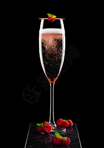 粉红玫瑰香槟的优雅杯子红莓加鲜和薄荷叶黑色大理石板上图片