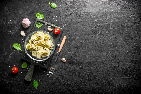 含大蒜丁叶和菠菜的子黑色生锈背景的子大蒜丁叶和菠菜的子图片