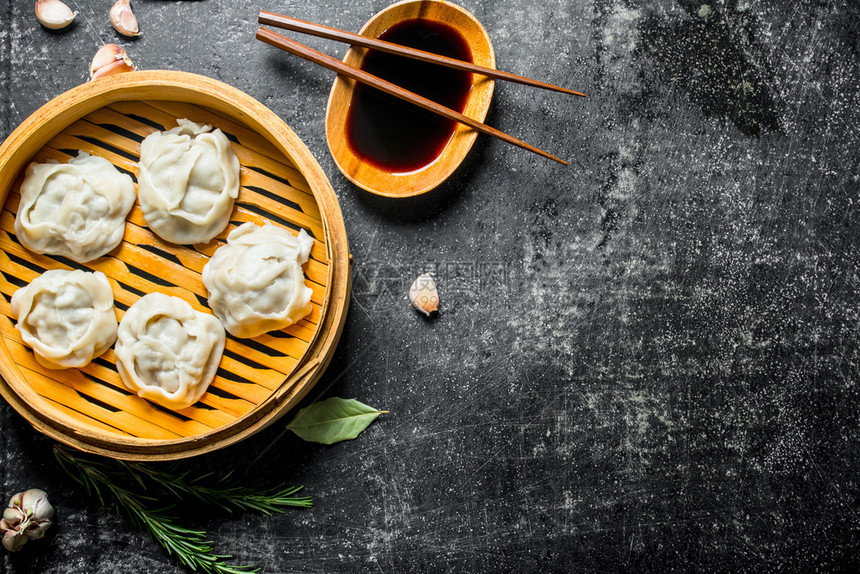 传统食物竹蒸汽机中含酱油的芒果卷子深色生锈背景图片