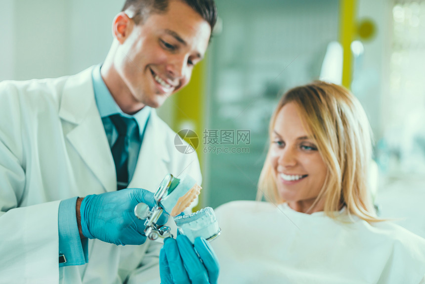 年轻牙医与满意病人交谈图片