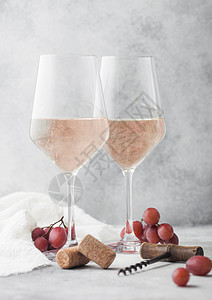 玫瑰粉红夏日葡萄酒装有软木葡萄和杯放在浅色桌底背景上图片