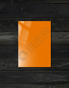 以黑木背景隔离的橙色小册子模拟板黑色木背景的橙小册子图片