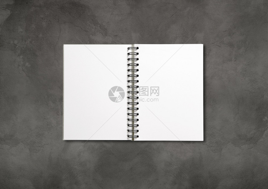 以暗混凝土背景隔离的空白开螺旋笔记本以暗混凝土背景隔离的空白开螺旋笔记本图片