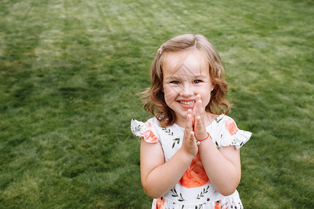 快乐的小女孩笑在绿草的背景上童年的概念准备接受你的文字标志或符号图片