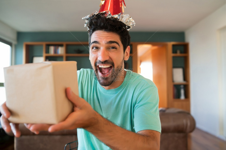 年轻男子通过视频电话庆祝生日以及在家时的礼物新正常生活方式概念图片