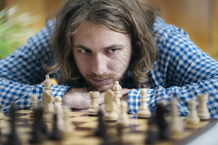 长发的年轻人在家玩象棋游戏想着下一届象棋下一届象棋图片
