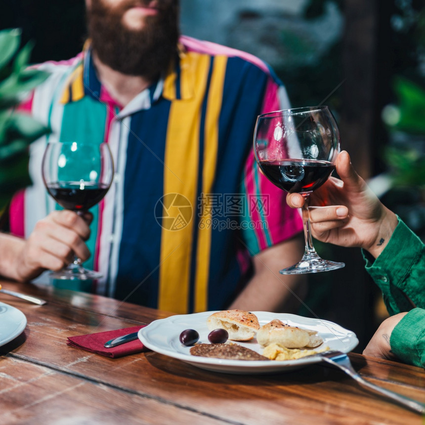 一对夫妇在约会时喝红酒和享受浪漫素食晚宴的正方形象图片