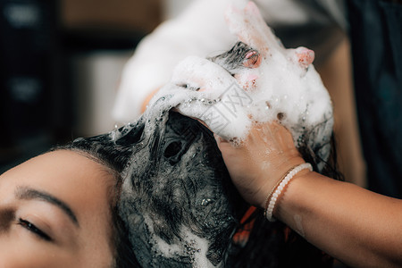 理发师用洗水女人和美容院的头发图片