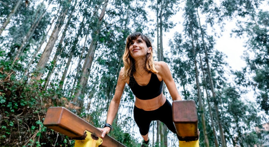 年轻女性在户外平衡木锻炼体能图片