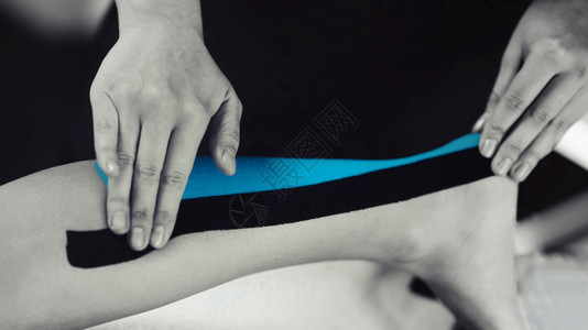 阿基里翁使用蓝色胶带对受伤女病人进行动脉录影治疗的黑白画面背景