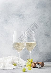 白杯自制的夏日清酒带软木和葡萄放在轻石背景上高清图片