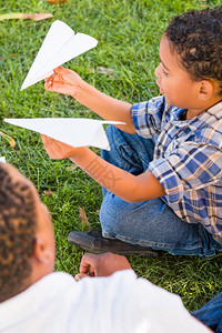 父亲和孩子在草地里玩纸飞机图片