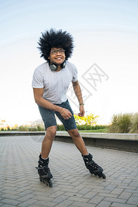 年轻拉丁男子在街上户外滚动的肖像体育概念城市图片