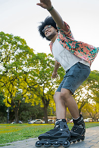 年轻拉丁男子在街上户外滚动时练习技能的肖像体育概念城市图片