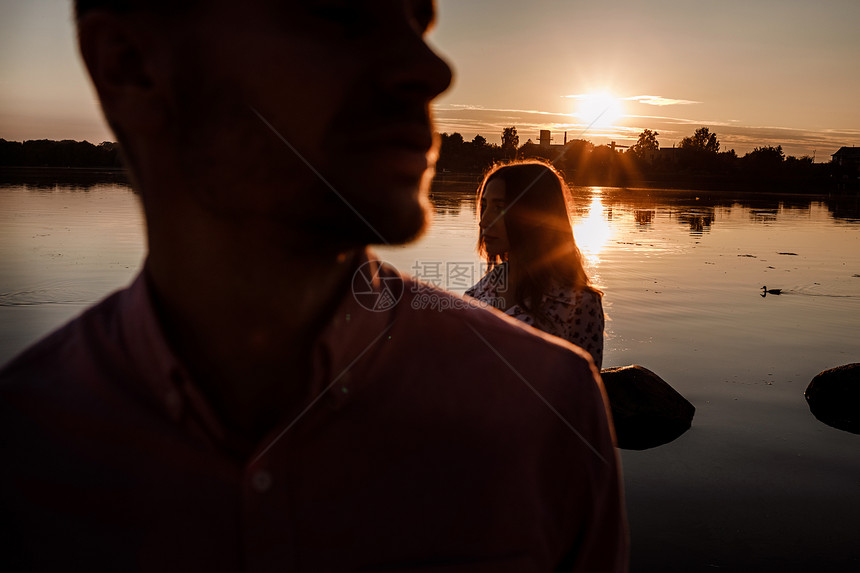 情侣在日落时的湖边约会的剪影图片