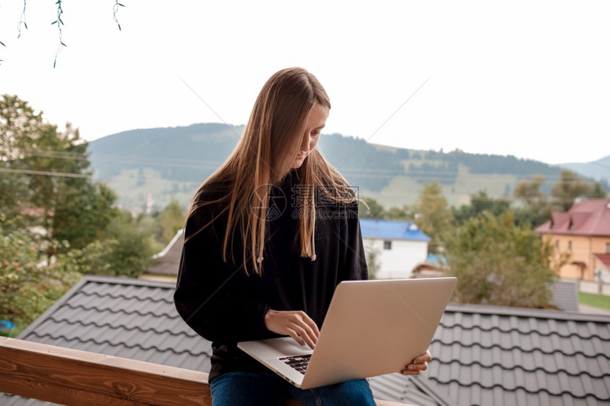 一位妇女坐在木制阳台上图片