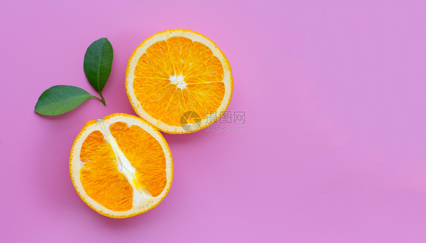 高维生素c多汁和甜新鲜橙色水果粉红背景的绿叶图片