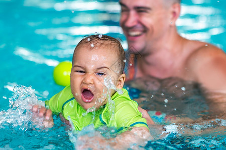 在游泳班池里父亲和男婴在游泳池里图片