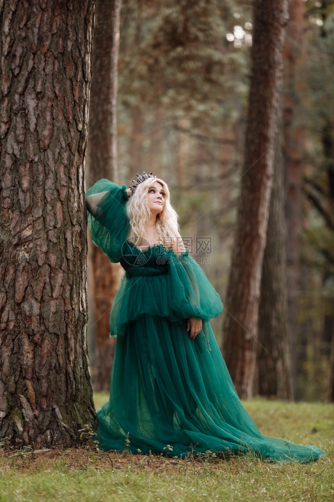 美丽的年轻金发女皇公主走秋天绿林神秘古老的中世纪闪亮王冠长夜绿衣神奇的幻想年轻美丽的金发女皇图片