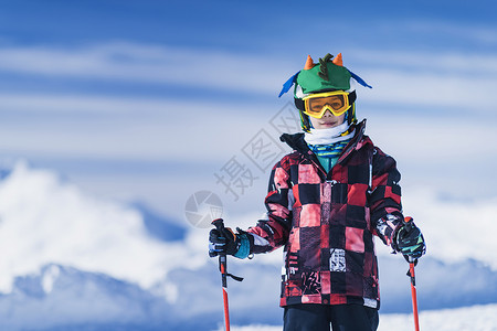 在山顶滑雪区穿多彩服装的男孩图片
