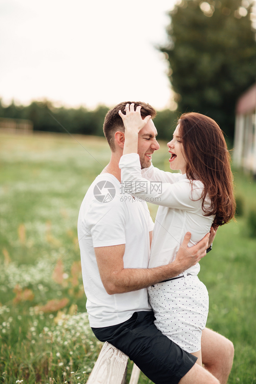 美丽的年轻夫妇在温暖的夏日阳光明媚子在公园户外玩乐美丽的年轻夫妇在温暖的夏日阳光明媚子在公园户外拥抱和玩乐图片