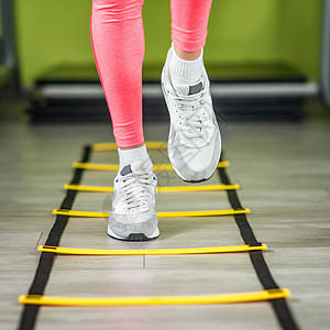 女青年在健身房的梯上运动图片