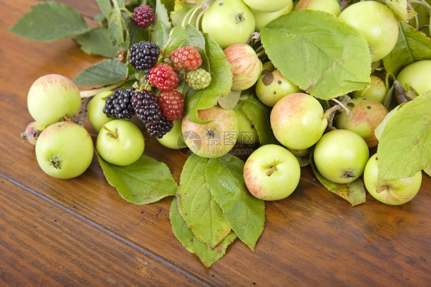 木制桌上的苹果和草莓图片