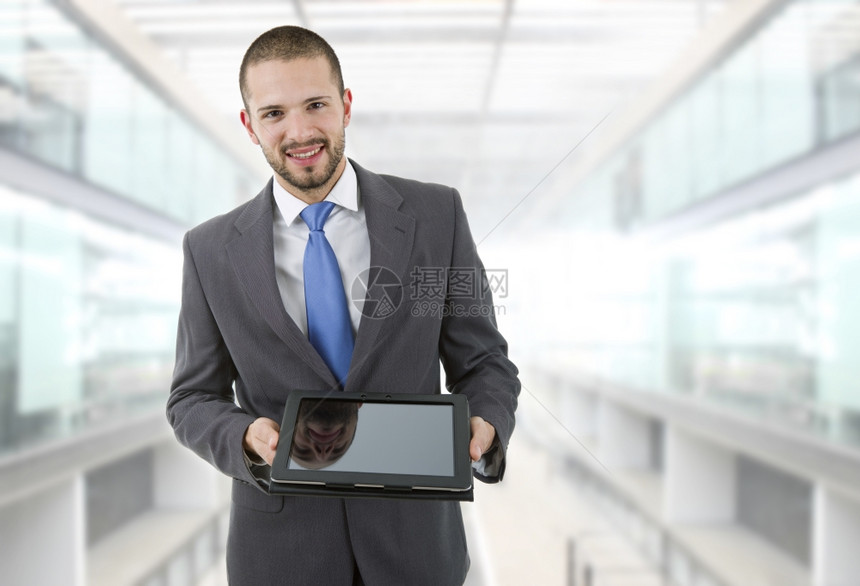 办公室里拿着平板电脑的年轻商人图片