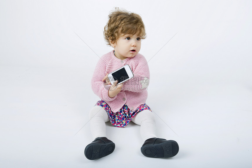 手机灰色背景的年轻婴儿图片