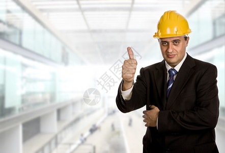 商人在办公室用拇指举起他的大图片