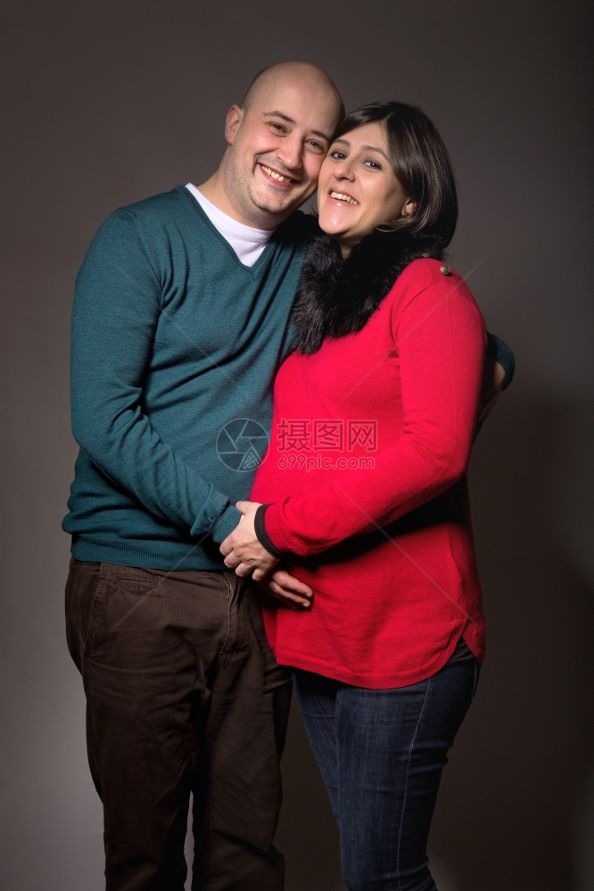 身陷黑暗背景的幸福怀孕夫妇图片