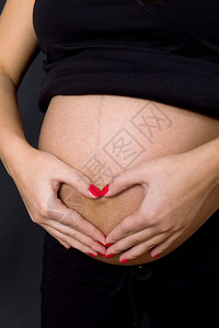 年轻孕妇肚子黑人背景图片