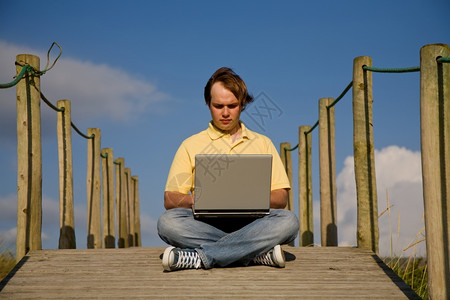 在海滩上做电脑工作的年轻人背景图片