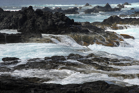 海浪线在海浪横冲直撞的岸上岩石背景