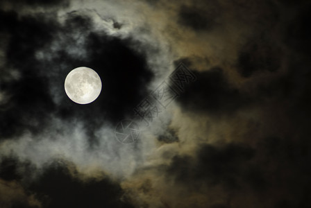 月亮上垂钓在黑暗的夜中在云上飘扬大月亮背景