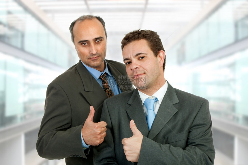 两个商人在办公室里举起大拇指图片