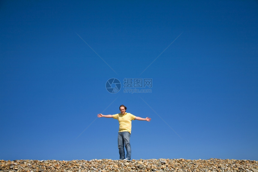 男人在海滩上张开双臂图片